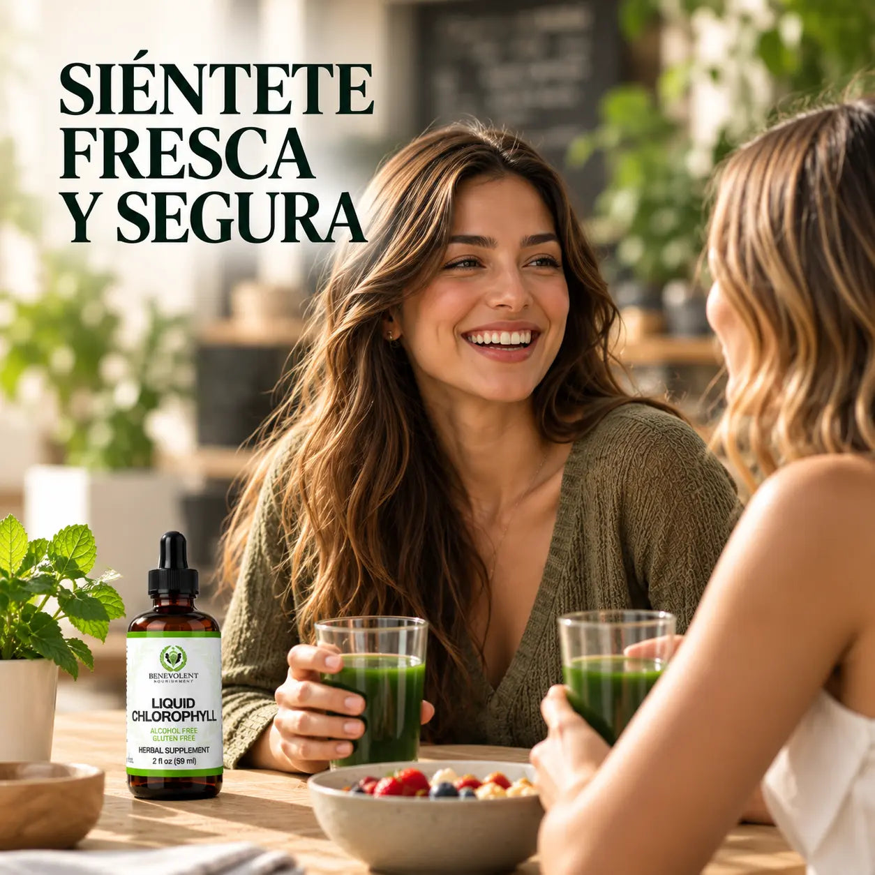 Dos amigas sonriendo con vasos de agua verde en una mesa
