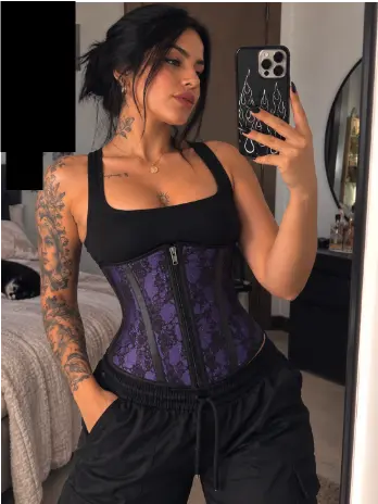 Clienta en selfie de espejo con la cinturilla morada de encaje sobre top negro y pantalón cargo negro