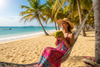 ayudame generando una imagen tipica de playa de una mujer tomando agua de coco en una playa colombiana
