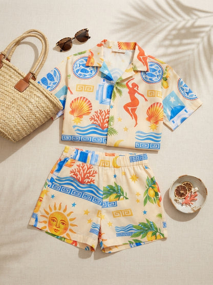 Flat lay del conjunto Sol Egeo: camisa y short con estampado de sol, cerámica azul, coral y palmeras